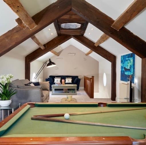 Games room with a pool table under oak beams